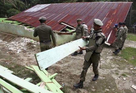 Indonesian civil service police members demolish a church at the Siompin village in Aceh Singkil, Aceh province