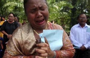 A resident cries as she prays during a Sunday mass near a burned church at Suka Makmur Village in Aceh Singkil